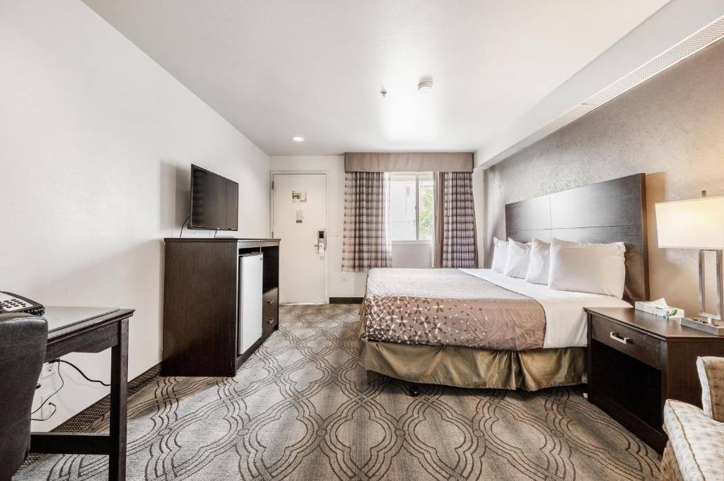 a hotel room with a bed and a desk at City Creek Inn & Suites in Salt Lake City