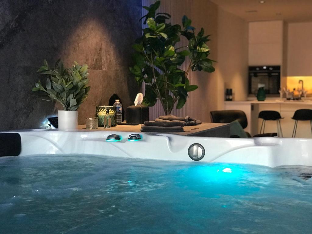 wanna z niebieskimi światłami w pokoju ze stołem w obiekcie L’ODYSSÉE SPA w mieście Seclin