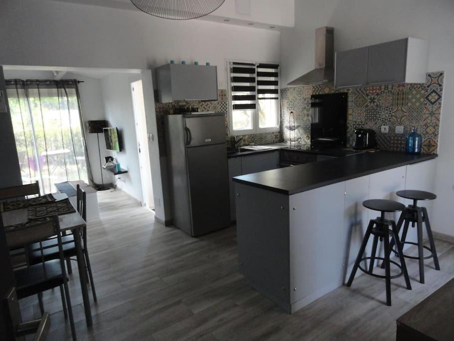 a kitchen with a counter and stools in a room at Gite L ABRI COSTIER in Villeveyrac