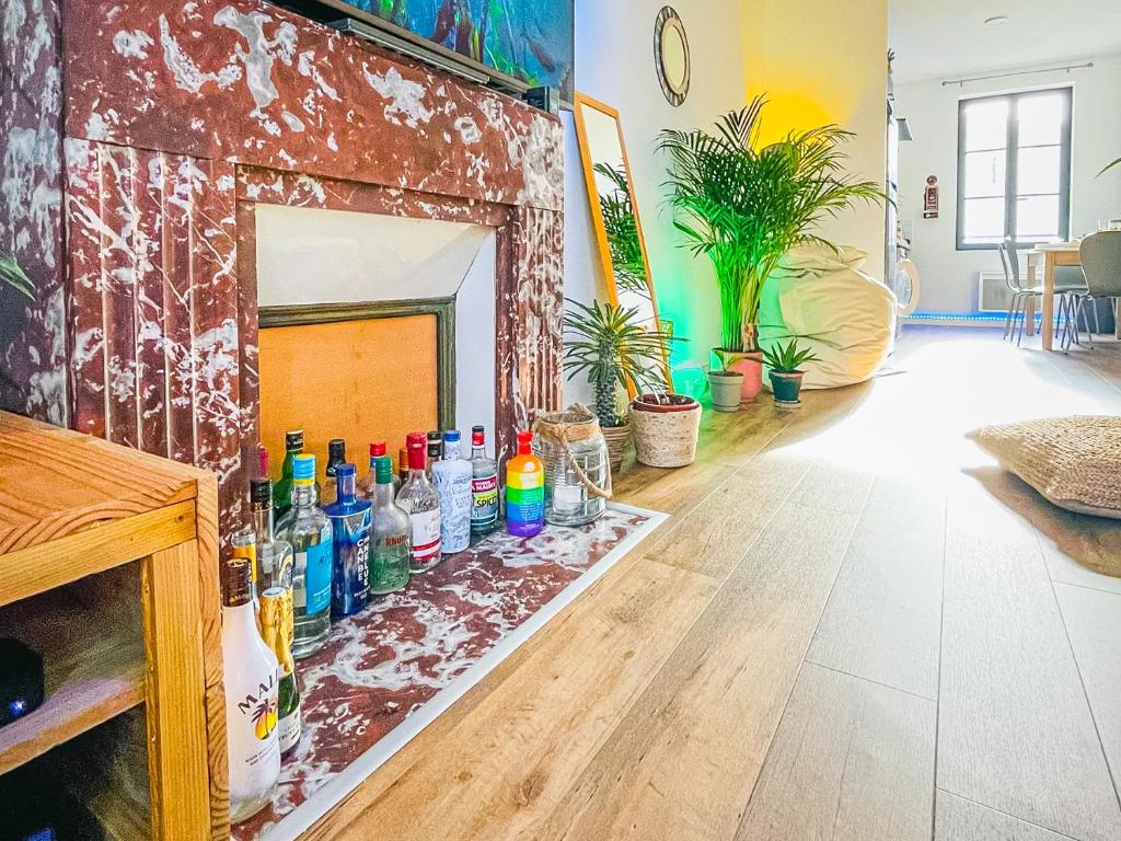 a room with a fireplace with bottles on the floor at Caribbean Spirit in Périgueux