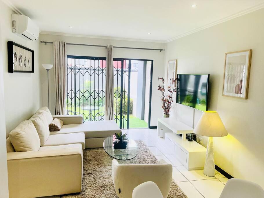 a living room with a couch and a table at Quebec Apartments - Fully Furnished & Equipped 1 Bedroom Apartment in Sandton