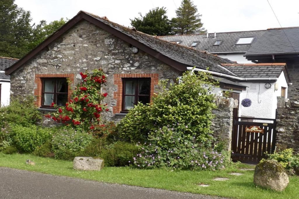 a stone house with flowers in front of it at Dairy Cottage, Dulverton in Dulverton