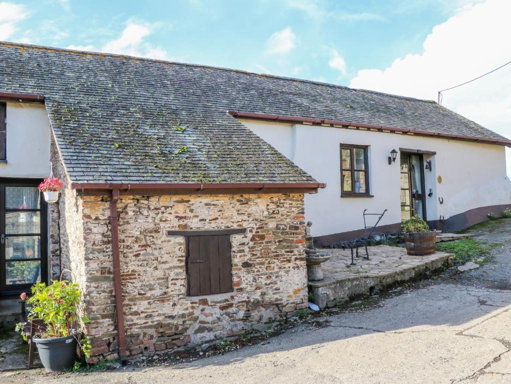 an old stone cottage with a welcoming front entrance at Pillhead Cider House in Bideford