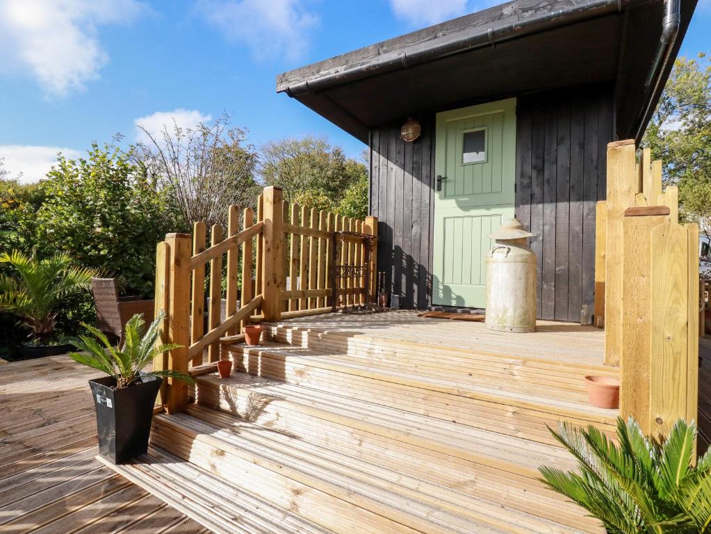 a wooden deck with a fence and a house at The View in Callington