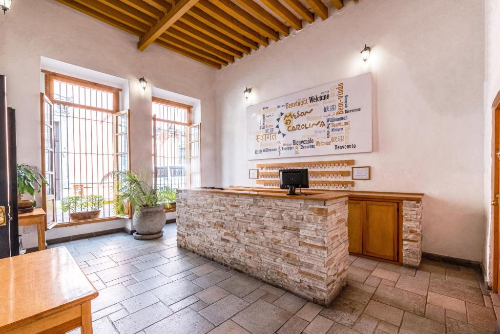ein Restaurant mit einer Steintheke in einem Zimmer mit Fenstern in der Unterkunft Hotel Meson de Carolina in Querétaro