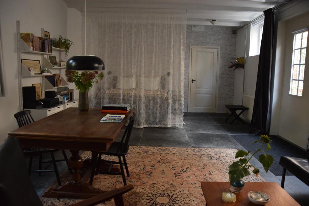 ein Wohnzimmer mit einem Tisch und ein Schlafzimmer in der Unterkunft Villa Conti in Dordrecht