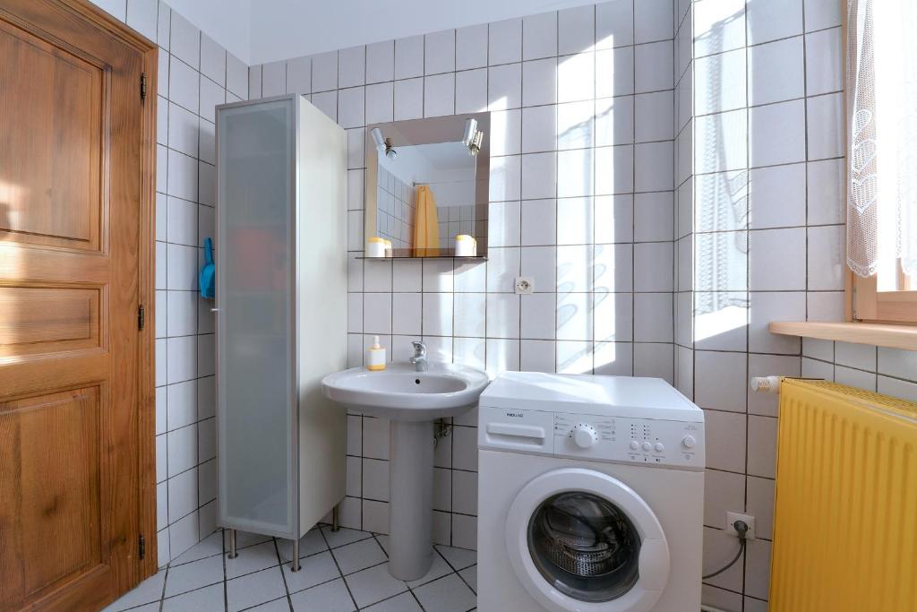 a bathroom with a washing machine and a sink at S&#39;Harzala Jaune in Bergheim
