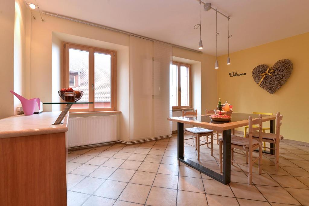 a kitchen and dining room with a table and chairs at S&#39;Harzala Jaune in Bergheim
