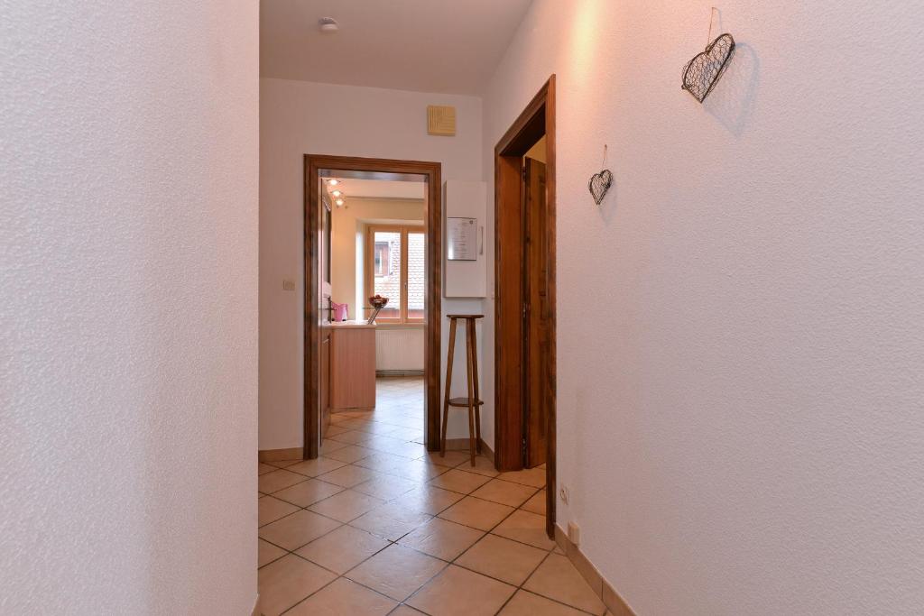 a hallway with a tile floor and a kitchen at S&#39;Harzala Jaune in Bergheim