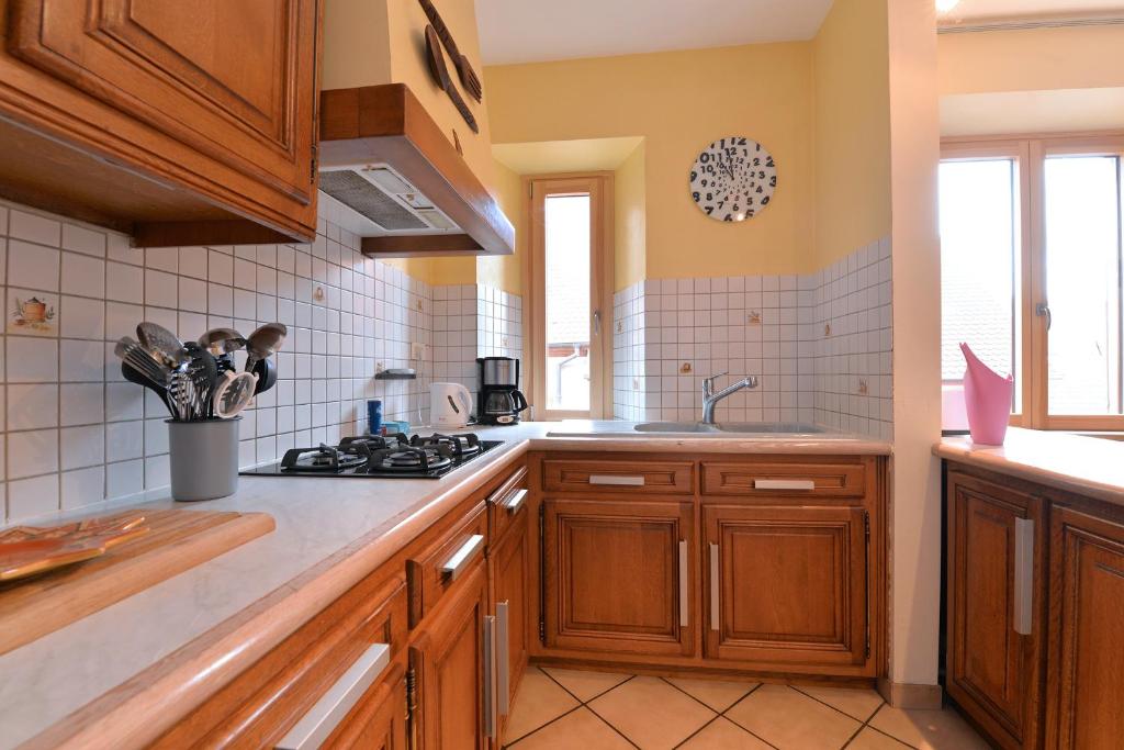 a kitchen with wooden cabinets and a stove top oven at S&#39;Harzala Jaune in Bergheim