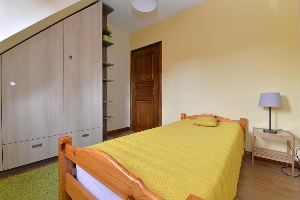 a bedroom with a bed with a yellow bedspread at S&#39;Harzala Jaune in Bergheim
