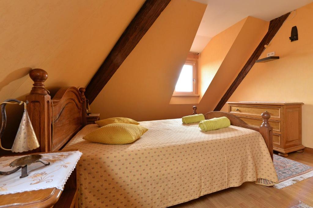 a bedroom with a bed with yellow pillows on it at S&#39;Harzala Jaune in Bergheim