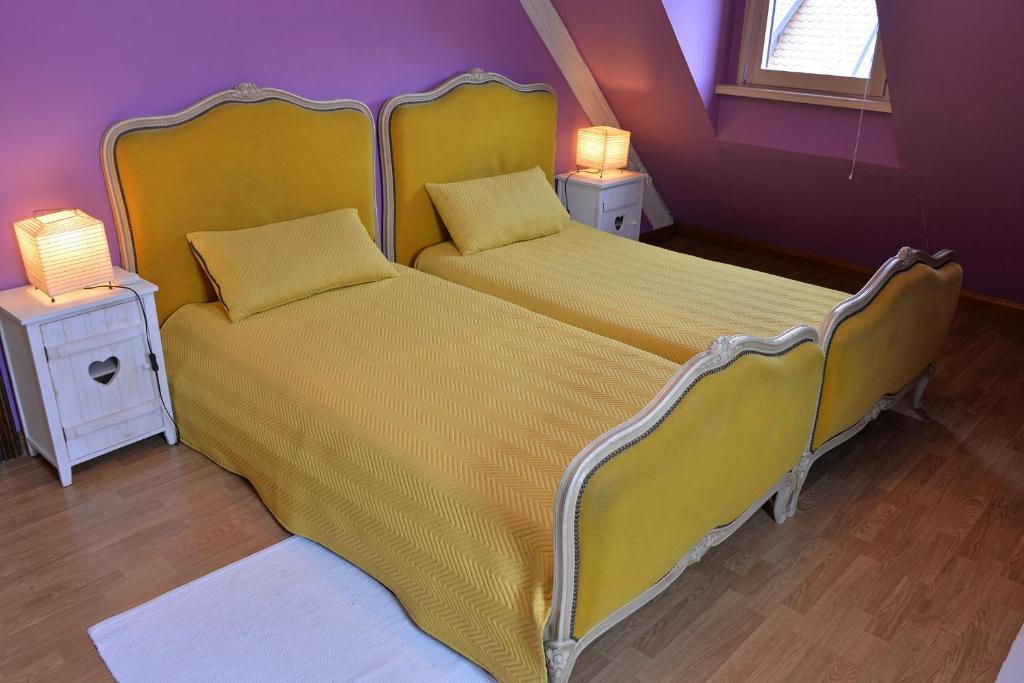 two beds in a room with two lamps on tables at S&#39;Harzala Jaune in Bergheim