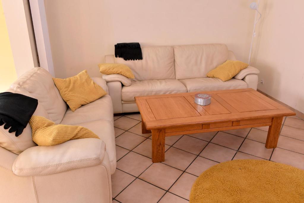 a living room with two couches and a coffee table at S&#39;Harzala Jaune in Bergheim
