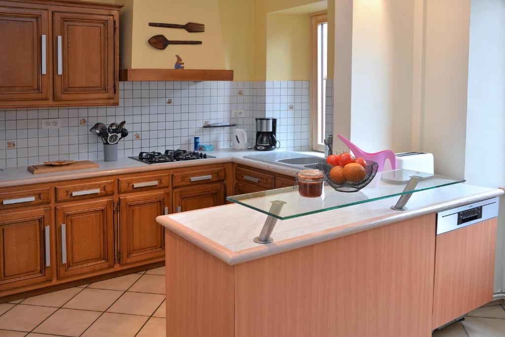 a kitchen with a counter with a bowl of fruit on it at S&#39;Harzala Jaune in Bergheim