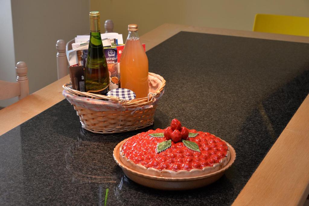a fruit pizza on a counter with a basket of drinks at S&#39;Harzala Jaune in Bergheim