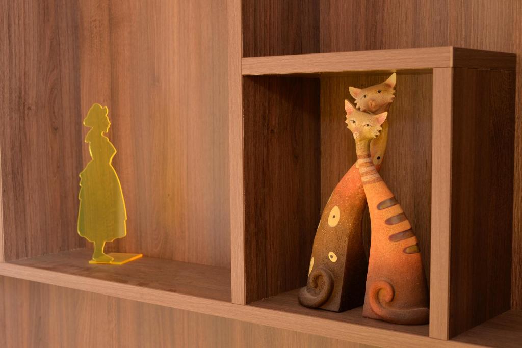 a wooden shelf with a toy cat and a figurine at S&#39;Harzala Jaune in Bergheim