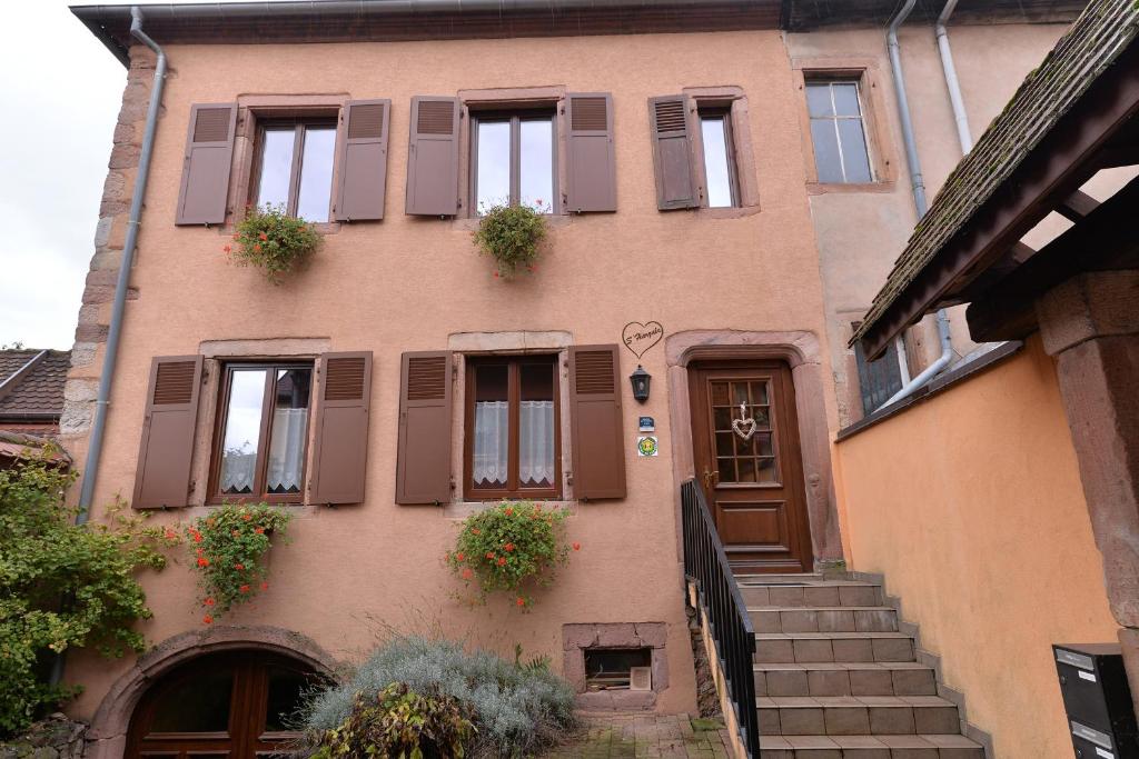 un edificio con puertas y ventanas con plantas. en S'Harzala Jaune, en Bergheim