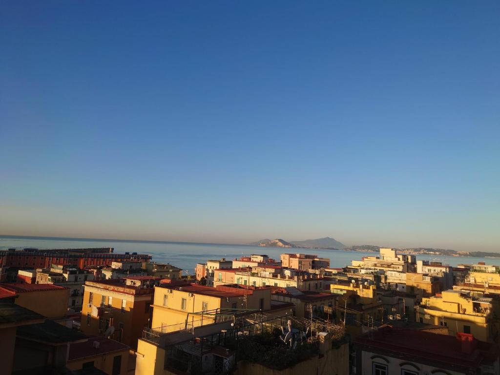 a city with buildings and the ocean in the background at Casa Flegrea Bagnoli in Naples