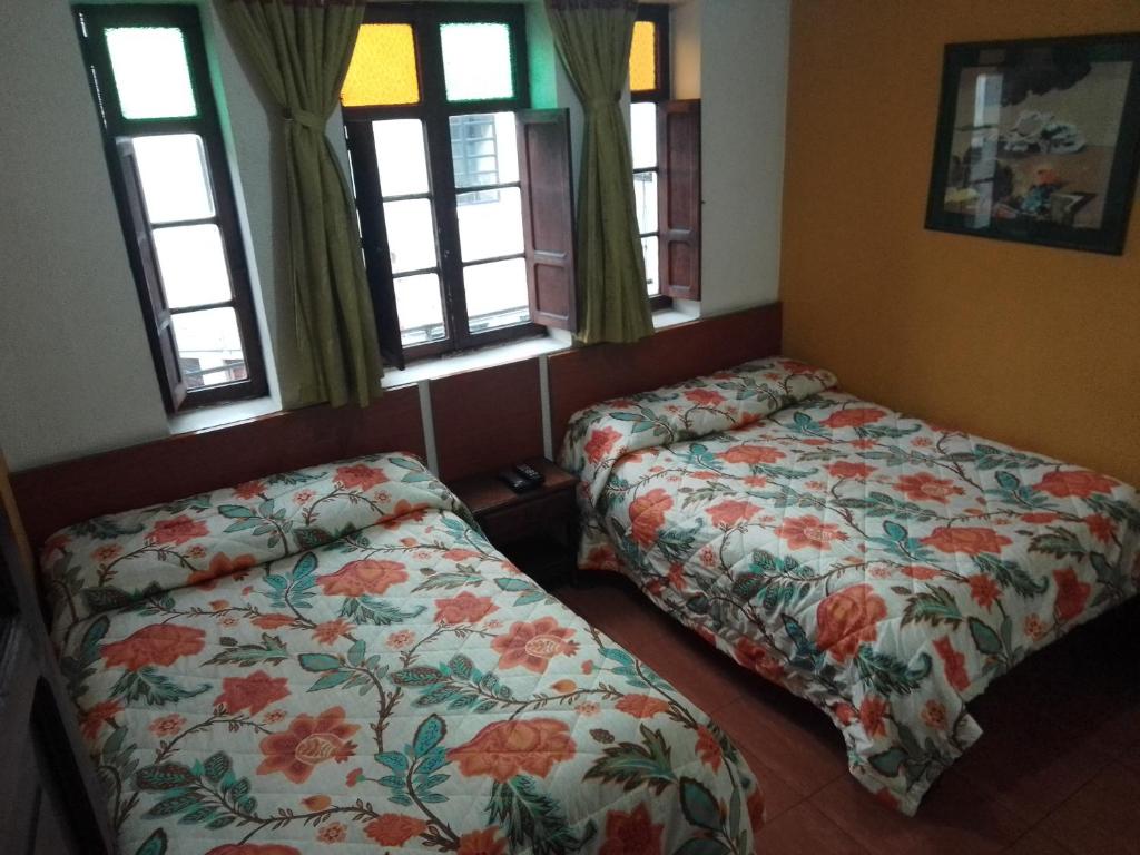- une chambre avec 2 lits et 2 fenêtres dans l'établissement Hotel El Dorado La Candelaria, à Bogotá