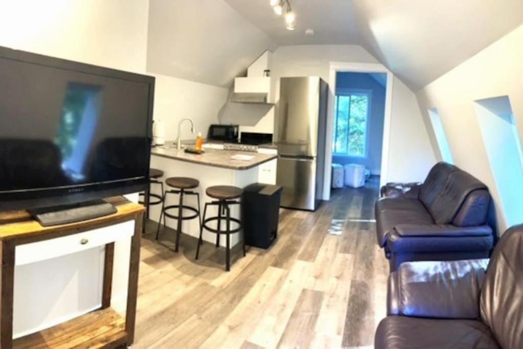 a living room with a couch and a kitchen at Rustic 1-Bedroom farm style loft with fire pit in Cobble Hill