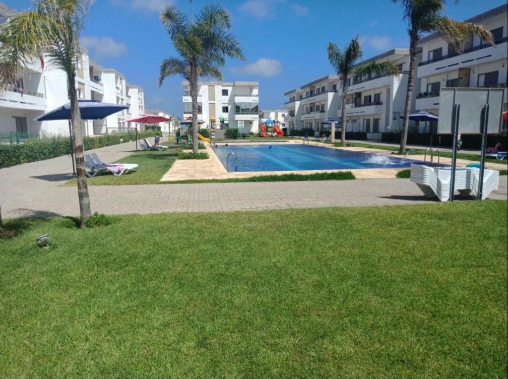 una piscina di fronte ad alcuni edifici di appartamenti di Mohammédia Marbella beach appartement familliale a Minaret de Mansuria