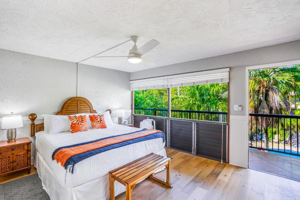 a bedroom with a bed and a balcony at Prince Kuhio 323 in Koloa