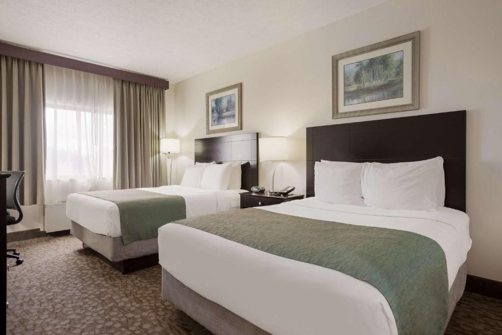 a hotel room with two beds and a television at Best Western Kendallville Inn in Kendallville