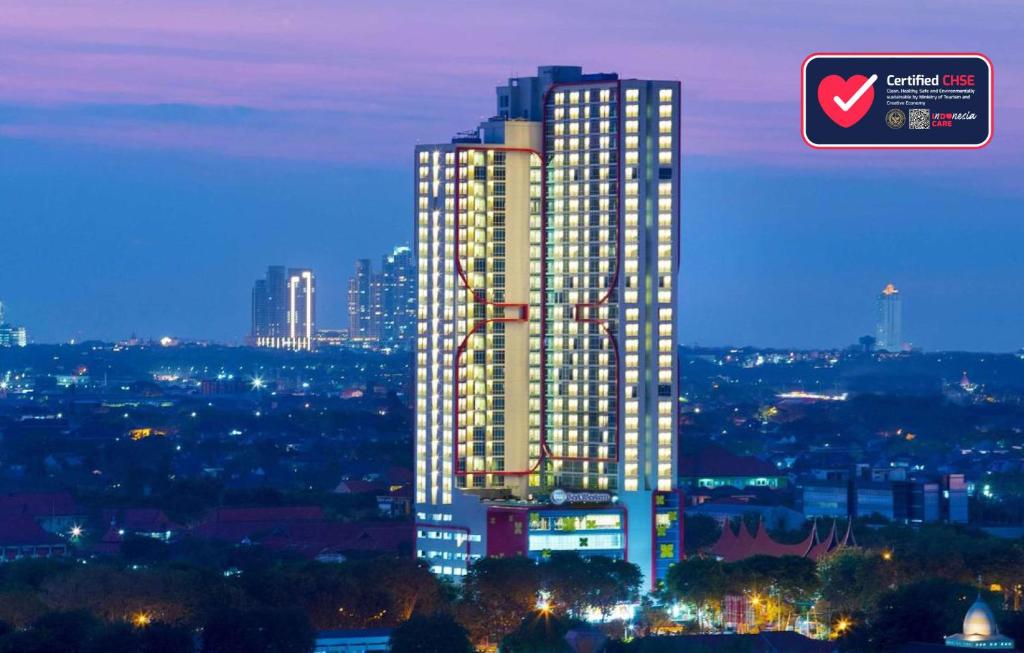 een weergave van een hoog gebouw in een stad 's nachts bij Best Western Papilio Hotel in Surabaya