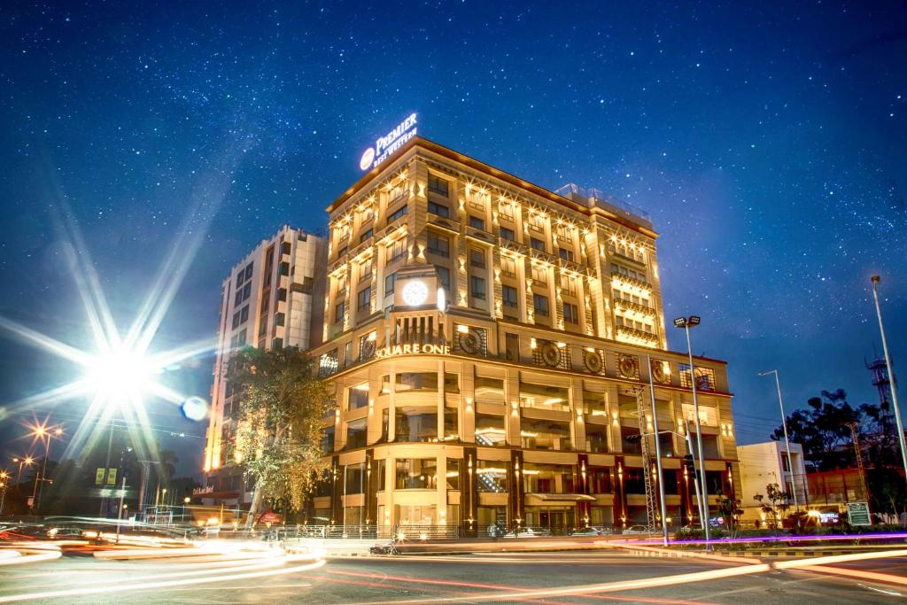 a building with a clock on the side of it at Best Western Premier Hotel Gulberg Lahore in Lahore