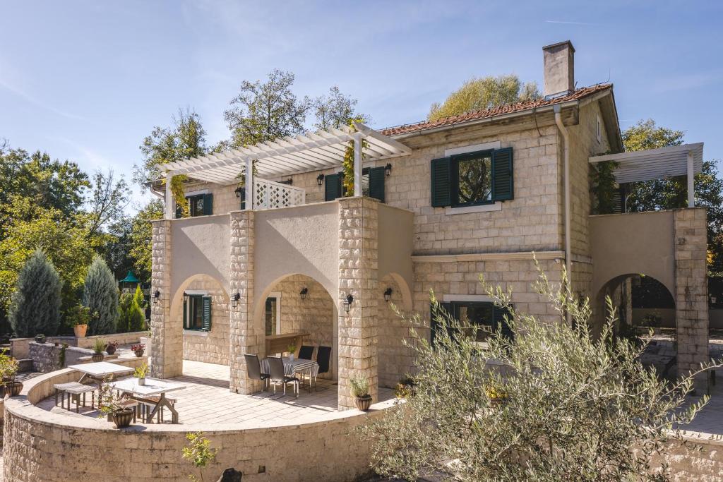 une maison avec une terrasse en face de celle-ci dans l'établissement Casa Ra, à Podgorica