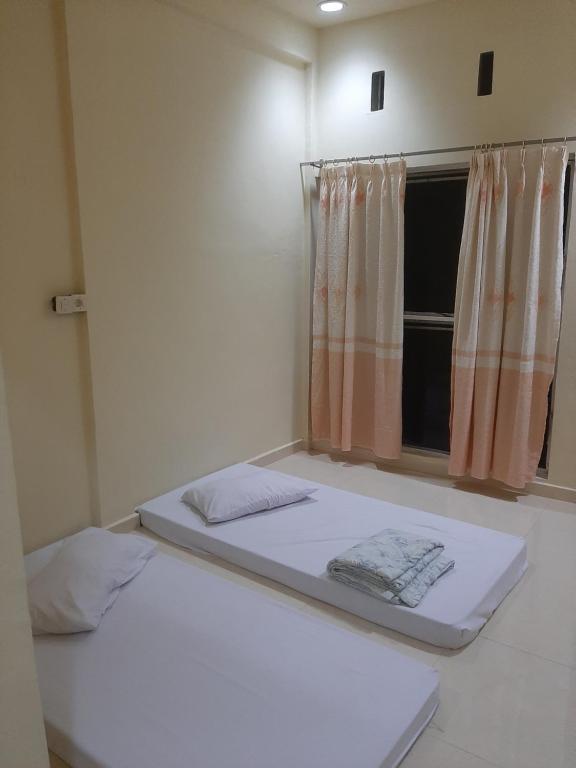 two beds in a room with a window at WisPing in Tanjung Pinang