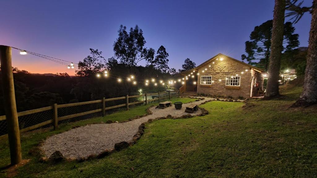 un granero de noche con luces en una valla en Villa Italia hospedagem en Gramado