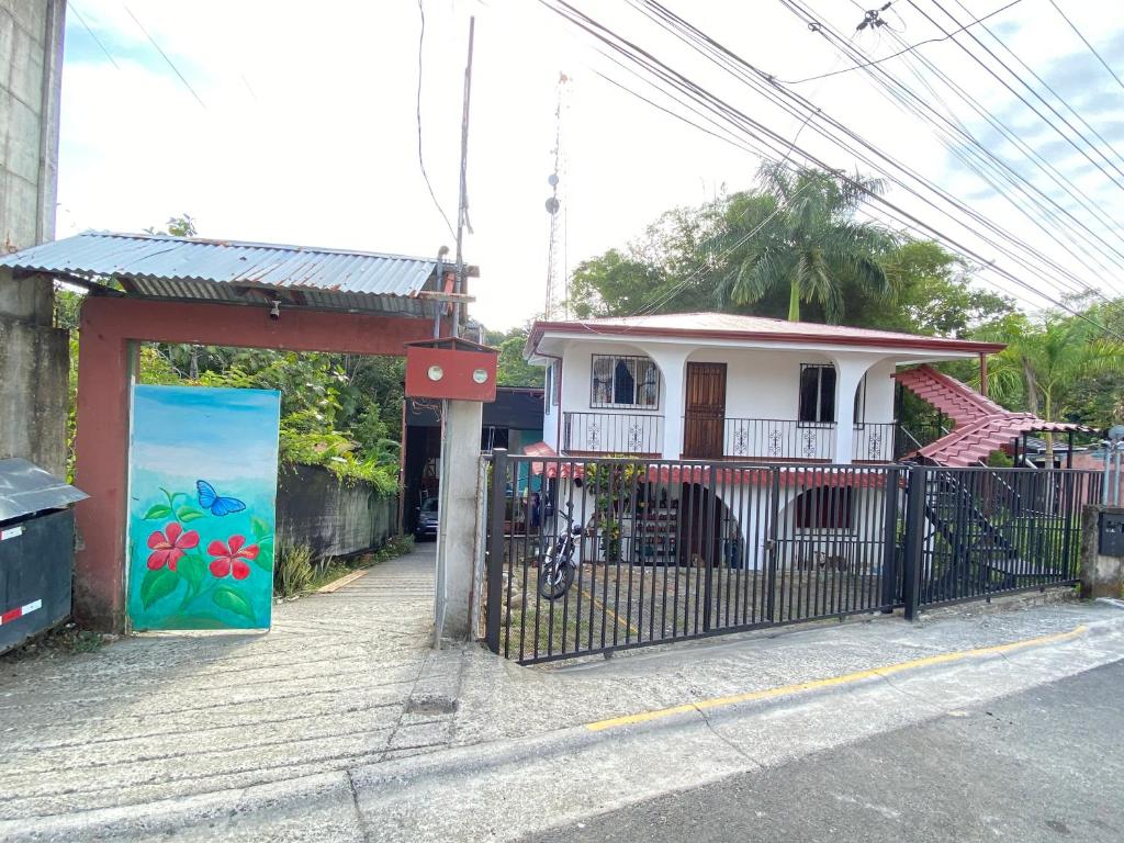 una pequeña casa con una puerta frente a un edificio en Blue Morpho House B&B, en Manuel Antonio