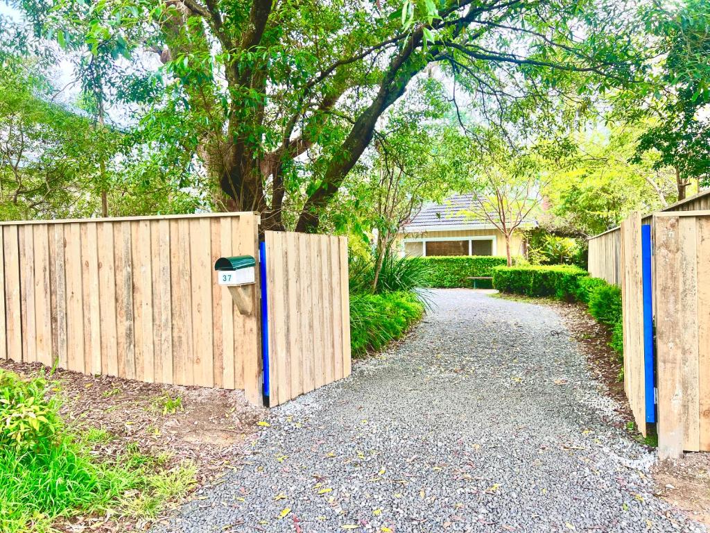 a wooden fence with a parking meter next to a driveway at Entire Blaxland Cottage in Blaxland