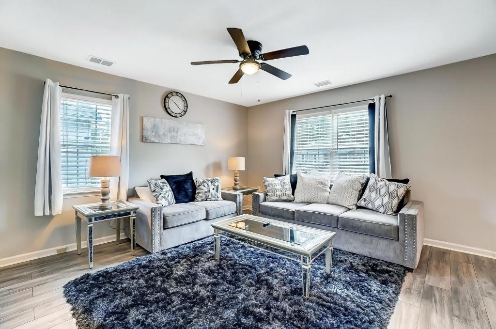 a living room with two couches and a ceiling fan at Cozy, 1-Level Cottage - 5 miles to Uptown CLT in Charlotte
