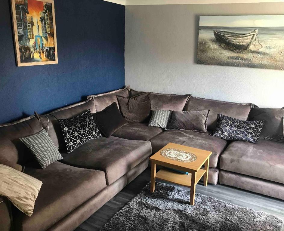 a living room with a brown couch and a table at Charming house welcome in Cardiff