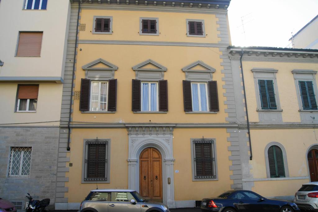 um edifício amarelo com carros estacionados em frente em Fra Bartolomeo em Florença