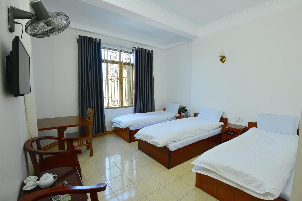 a hotel room with two beds and a television at Khách Sạn Đông Phương in Lạng Sơn