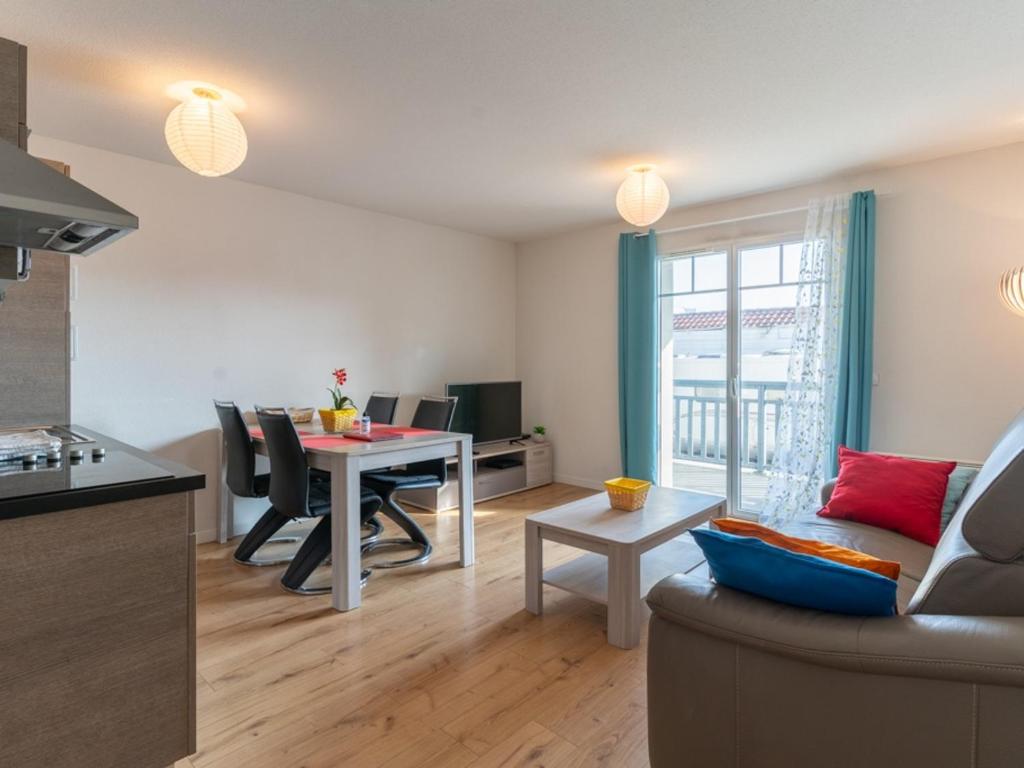 une cuisine et un salon avec une table et un canapé dans l'établissement Appartement T2 avec piscine, proche océan, linge et ménage inclus, à Biscarrosse Plage - FR-1-319-455, à Biscarrosse