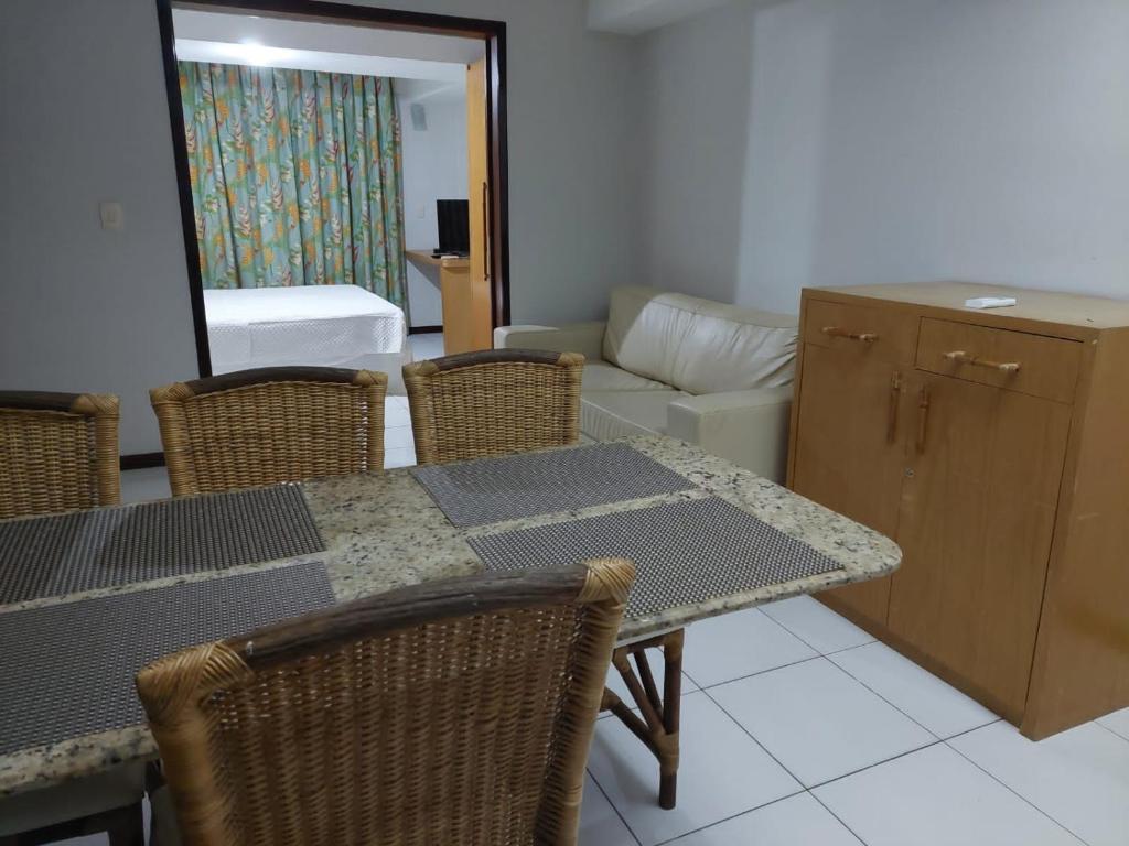 een eetkamer met een tafel en stoelen en een woonkamer bij Flat 305 - Flat no Vip Praia Hotel in Natal