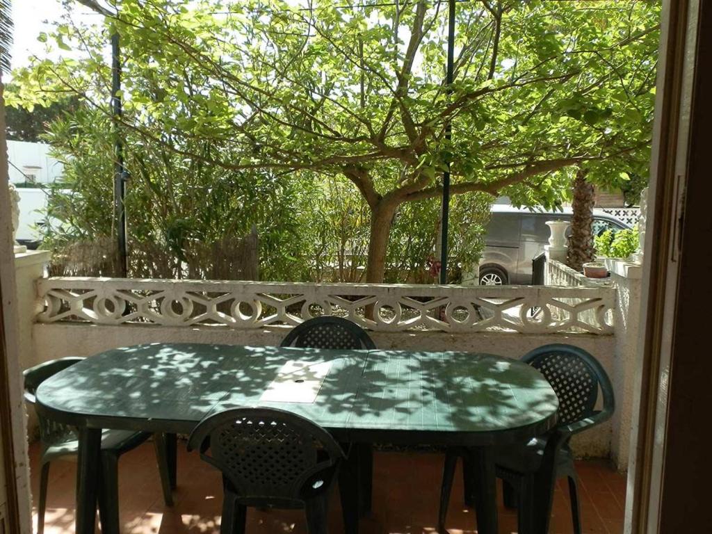 een groene tafel en stoelen op een patio bij Casa Deltebre, 2 dormitorios, 4 personas - ES-184-45 in Riumar