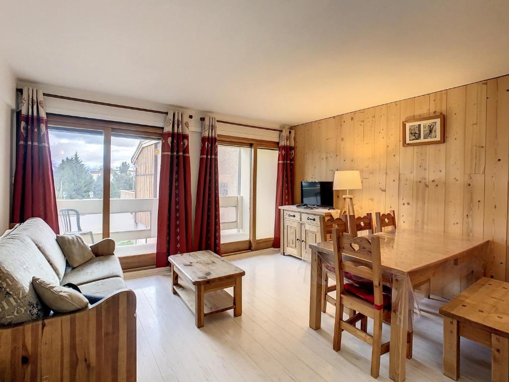 - un salon avec une table à manger et un canapé dans l'établissement Appartement lumineux 6 pers, style montagne, balcon sud, proche commerces et pistes - FR-1-417-151, à La Toussuire
