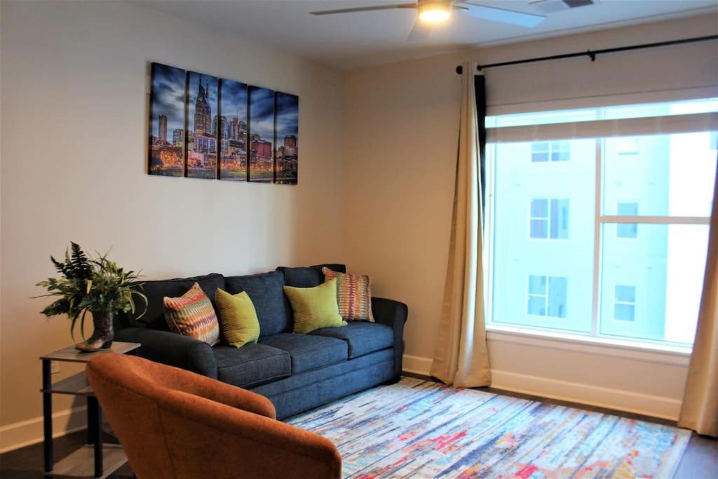 a living room with a blue couch and a window at Luxury in the Gulch in Nashville