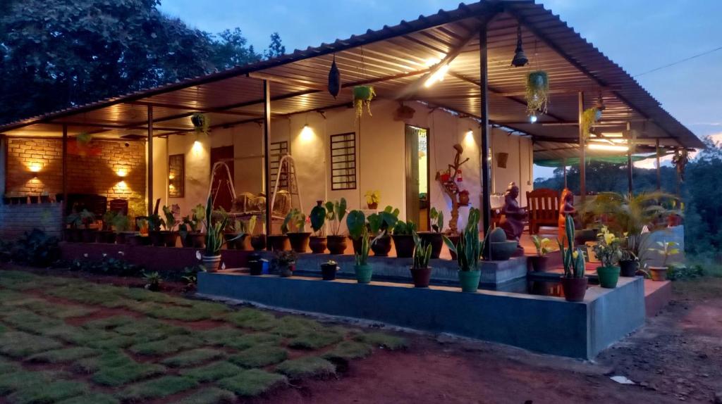 una casa con macetas delante de ella en Coorg Coffee Park Farmstay, en Somvārpet