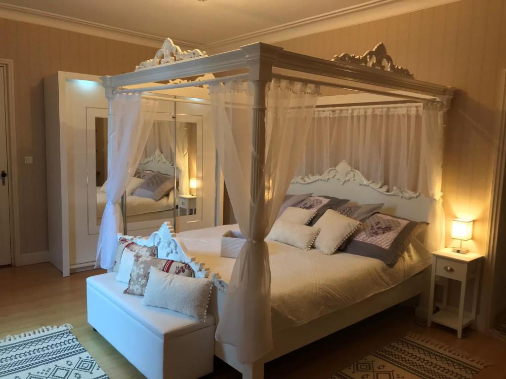 a bedroom with a canopy bed and a chair at les trois tilleuls in Loupiac-de-Cadillac
