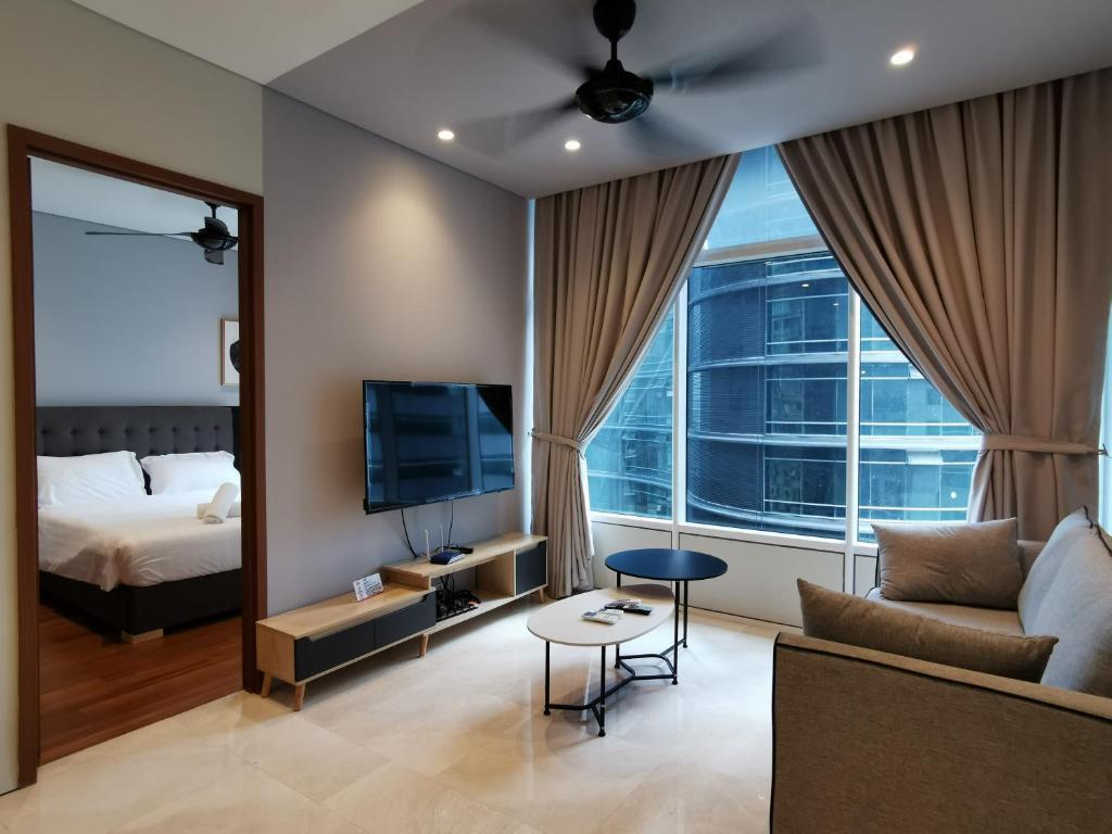 a living room with a couch and a tv and a bed at Sky Suites KLCC by Autumn Suites Premium Stay in Kuala Lumpur