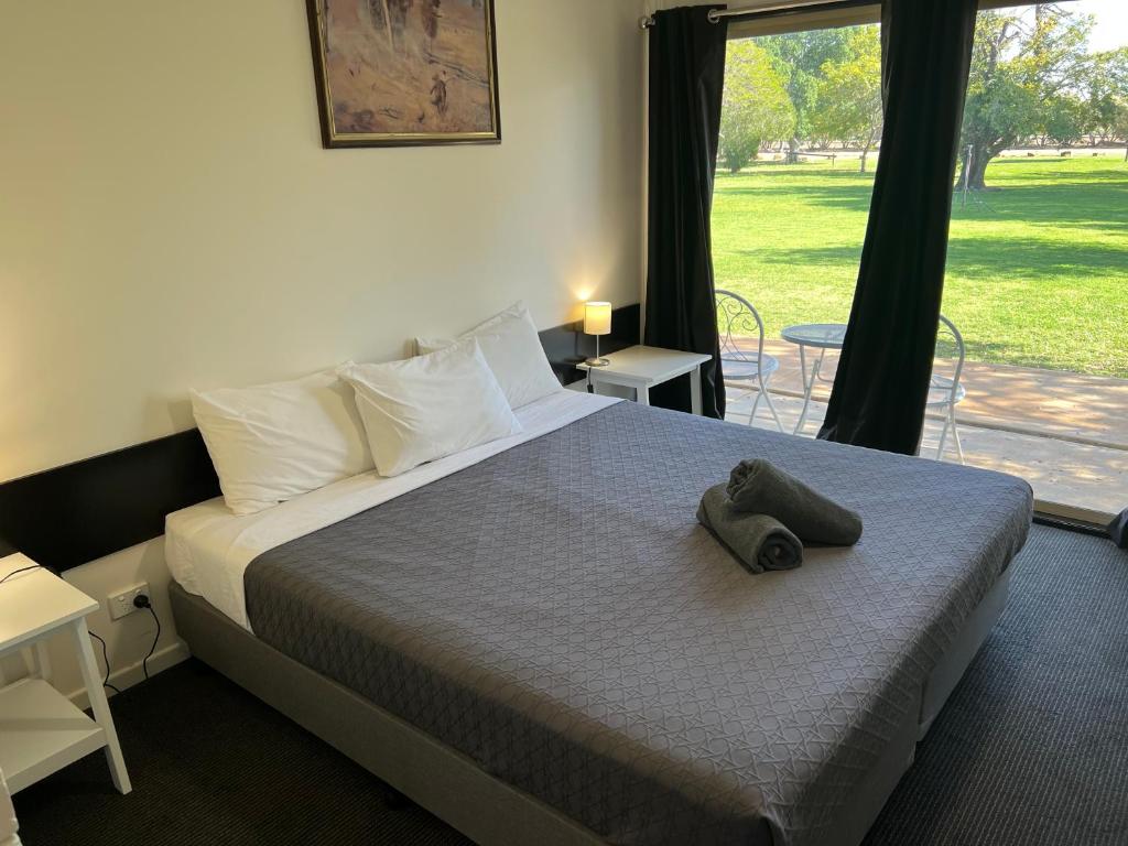 a bedroom with a bed with a hat on it at Jumbuck Motel - Oil Friendly Price in Longreach