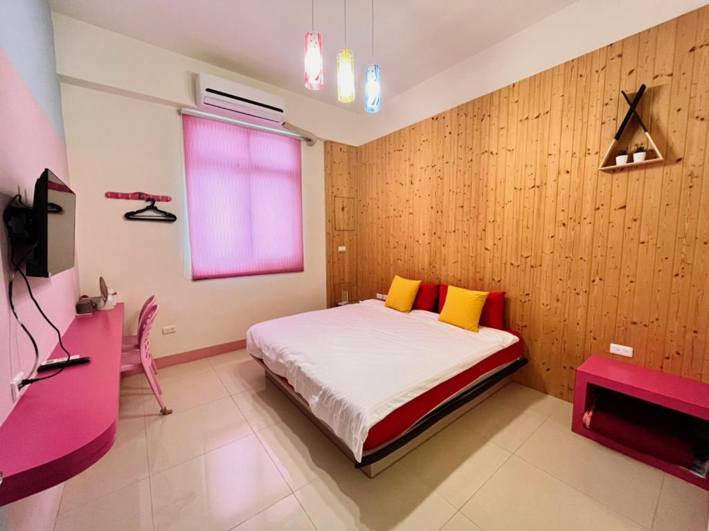 馬公市的住宿－樂在綺中民宿 第580號，一间卧室配有一张带黄色枕头的床和粉红色的窗户。