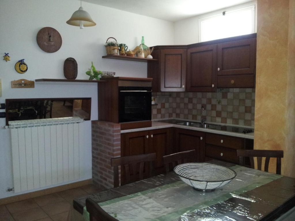 a kitchen with wooden cabinets and a table with a sink at Dimora2 MGM in Marconia